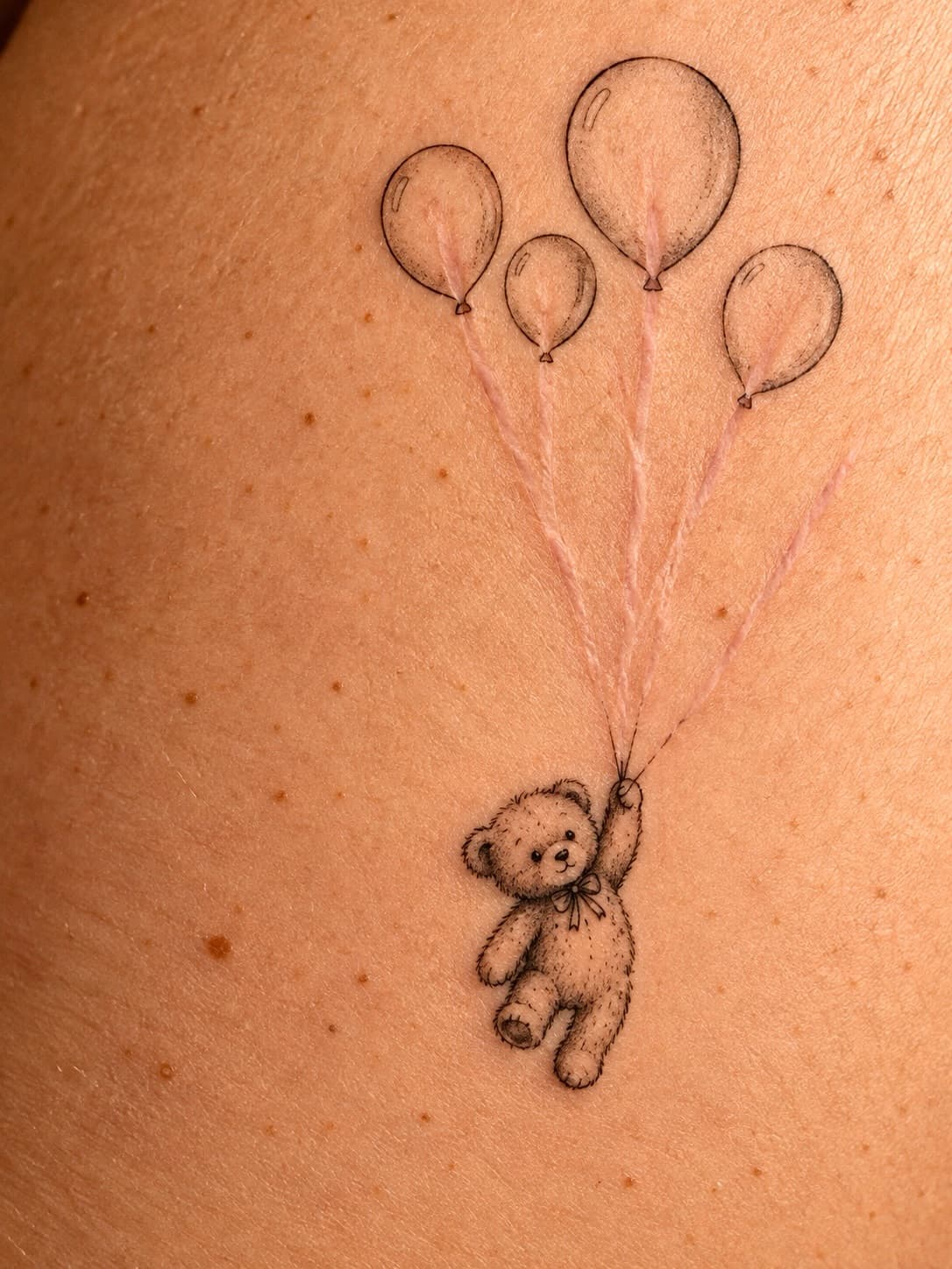 A Teddy Bear Lifted by Balloons